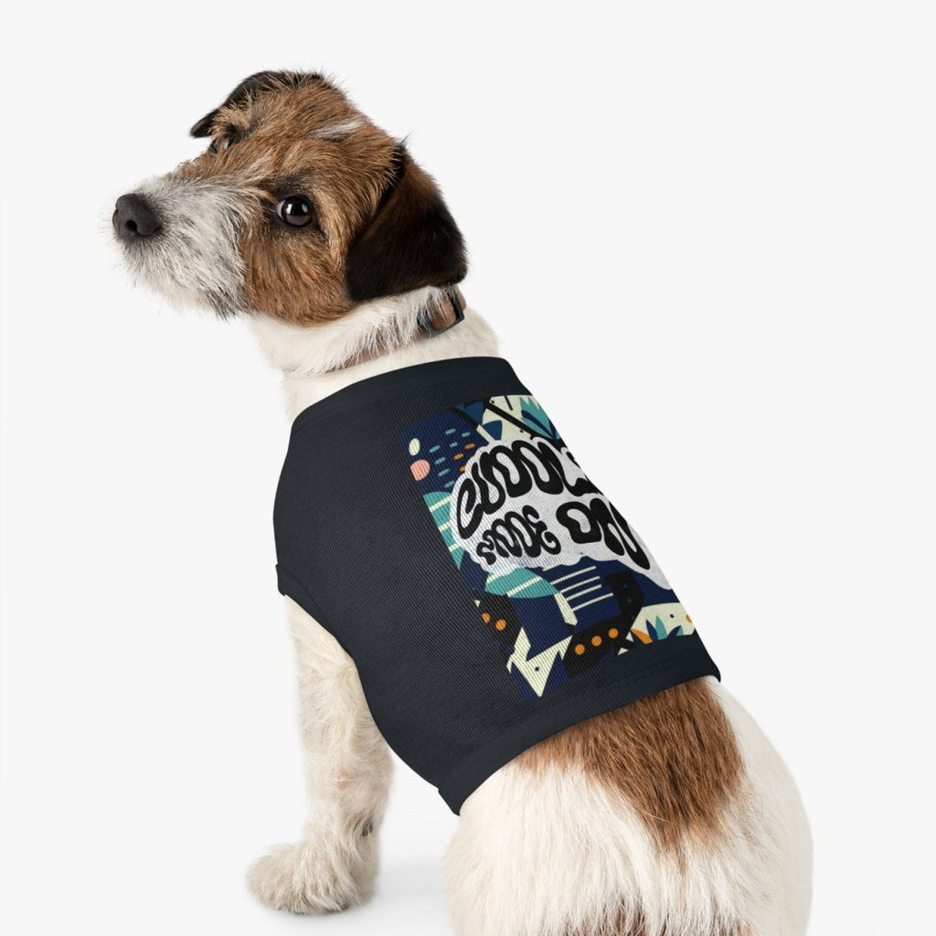 Dog wearing a black sleeveless shirt with colorful graphics on a white background