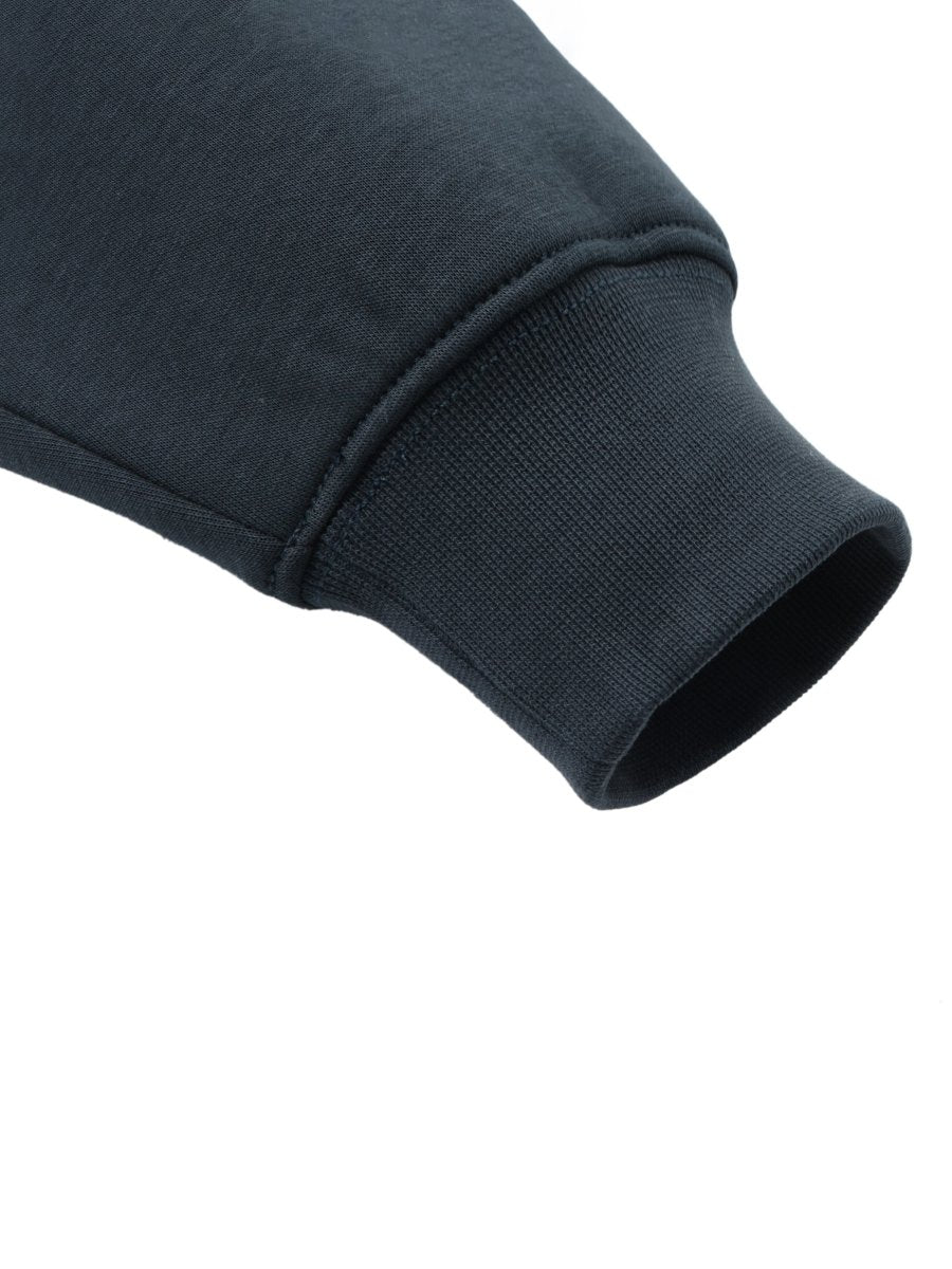 Close-up of a navy blue sweatshirt sleeve on a white background