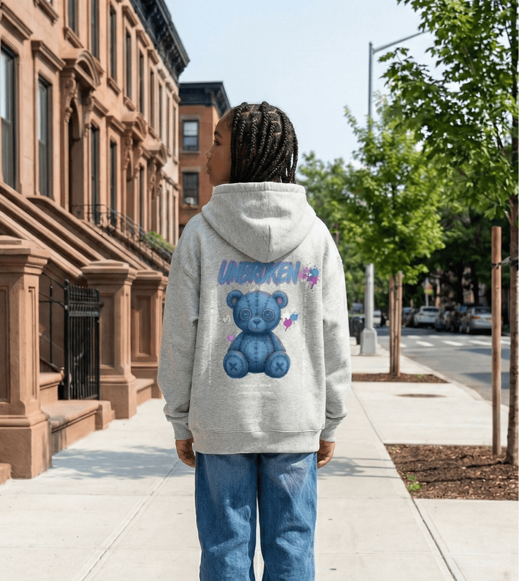 girl wearing a hoodie with a bear graphic on a city street