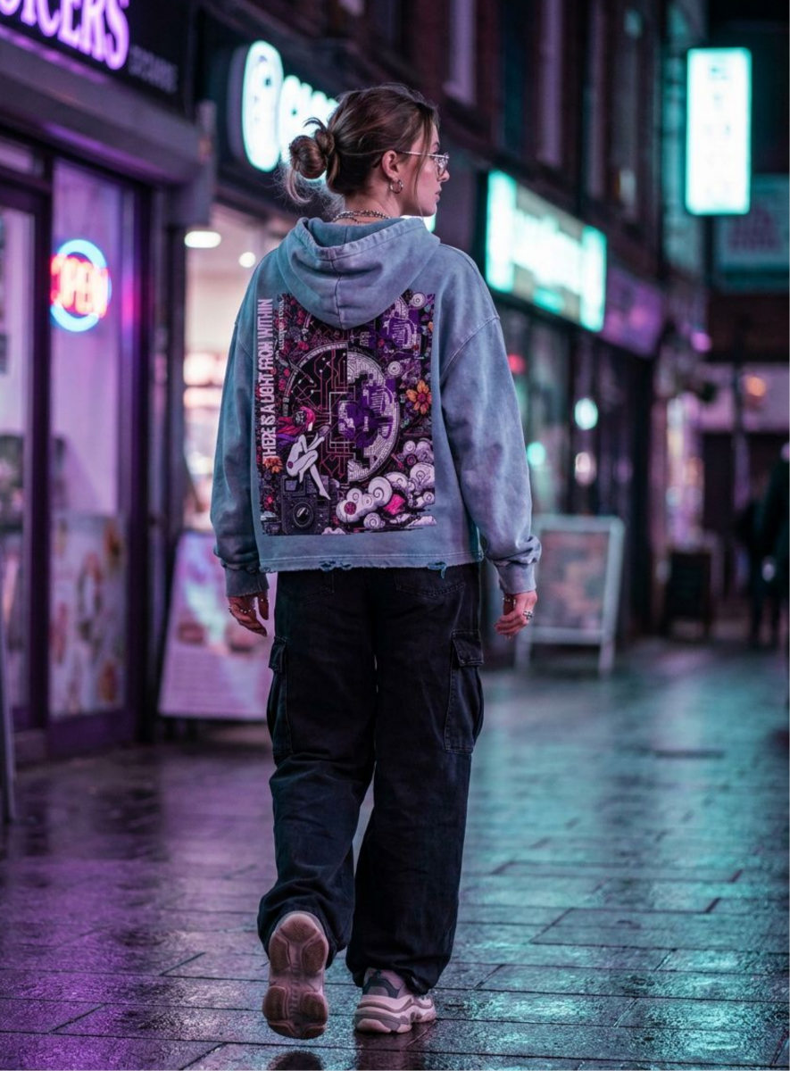 Person wearing a hoodie with a colorful design walking on a street at night.